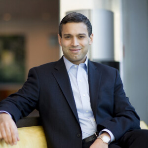 Vikram Mansharamani. Headshot of Vikram Mansharamani sitting in a chair wearing a black suit jacked over a light blue collared shirt.