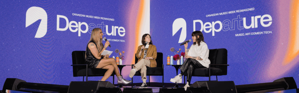 Vivek Shraya hosting a fireside chat with guests on stage at Departure Fest.